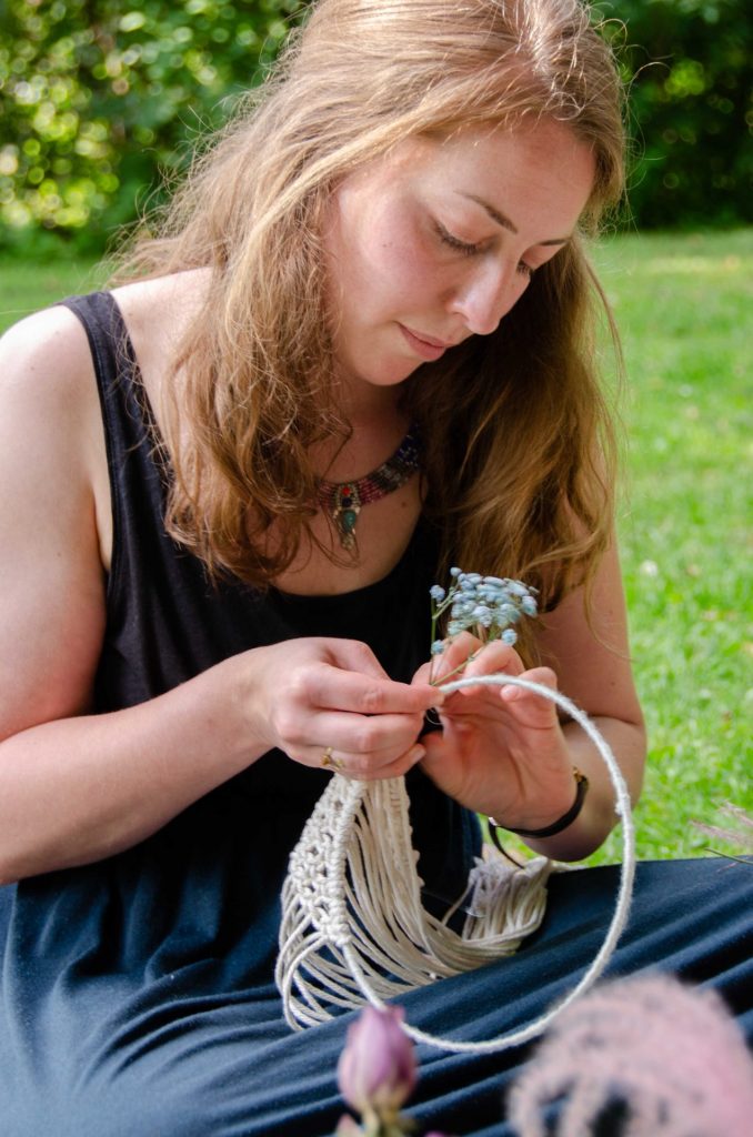 Eine junge Frau knüpft einen Makramee Wandbehang. Im Online Workshop die Grundlagen des Makramees lernen. 